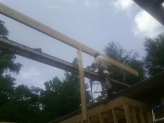 Carpenter setting a ridge beam over a new addition frame — Ice Dam Removal by Roofing Brothers in Almira