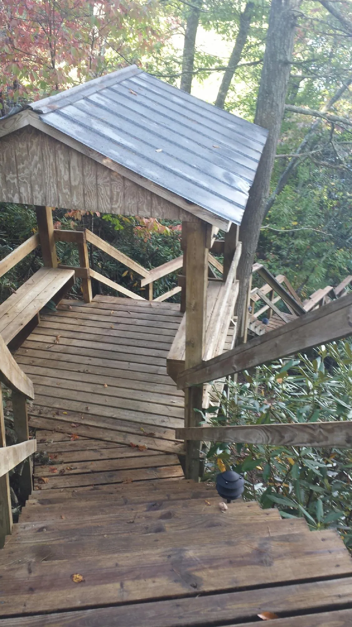 Metal roofed shelter over wooden steps on a wooded walkway — Skylight Repair & Installation work by our crew in Almira