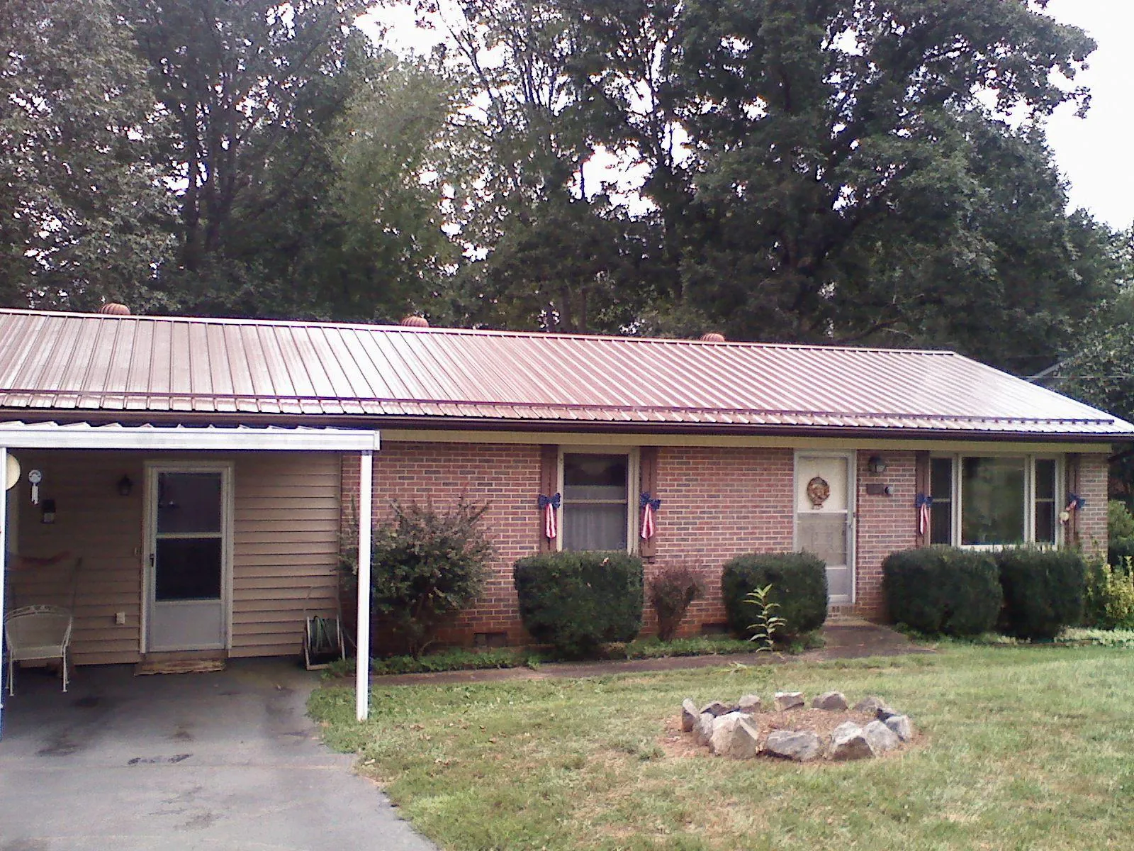 Bronze metal roof and carport on a brick ranch home — Roof Repair work by our crew in Almira